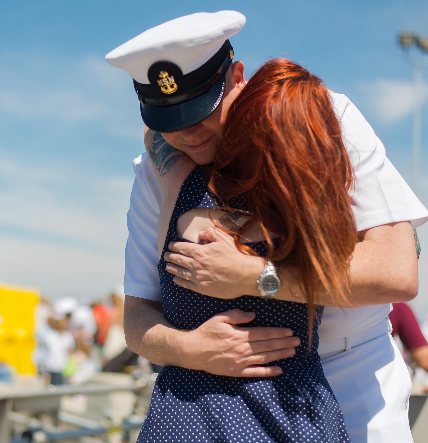 A member of the military hugging a woman